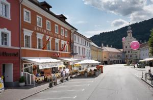 Eine Straße in einer Stadt mit Leuten, die an Tischen sitzen. in der Unterkunft Hotel Gasthof Kohlmayr in Gmünd in Kärnten