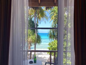 uma janela com vista para a praia em Athiri Beach Maldives em Dhigurah
