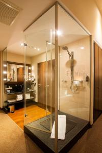 a bathroom with a glass door and a tub at Flemings Conference Hotel Wien in Vienna