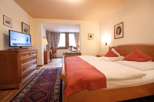1 dormitorio con 1 cama grande y TV en Reindl's Partenkirchener Hof en Garmisch-Partenkirchen