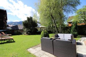 einen Garten mit einer weißen Couch und einem Zaun in der Unterkunft Reindl's Partenkirchener Hof in Garmisch-Partenkirchen