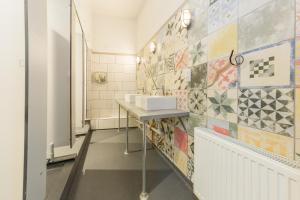 a bathroom with two sinks and a tiled wall at PubLove @ The Green man, Paddington in London