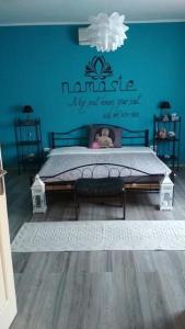 1 dormitorio con 1 cama con pared azul en Nita Vendégház en Solt