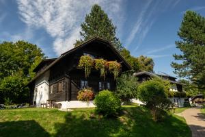 una casa con dei fiori sul lato di Naturel Hoteldorf Schönleitn a Latschach ober dem Faakersee