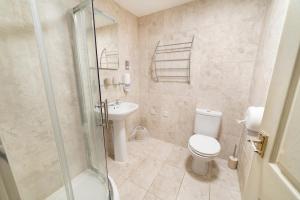 a bathroom with a shower and a toilet and a sink at Hotel Prince Regent in Weymouth
