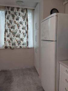 a kitchen with a white refrigerator and a window at Sweet Home in Burgas City +11 photos