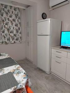 a kitchen with a refrigerator and a tv on a counter at Sweet Home in Burgas City