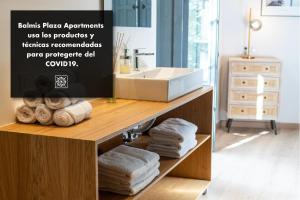 un bagno con lavandino e asciugamani su una mensola di Balmis Plaza Apartments ad Alicante