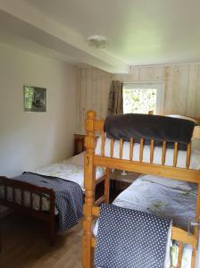 1 Schlafzimmer mit 2 Etagenbetten und einem Fenster in der Unterkunft Les Gites de la Renardière in Gueures