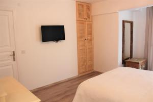 a bedroom with a bed and a television on the wall at Villamer Alaçatı in Alaçatı