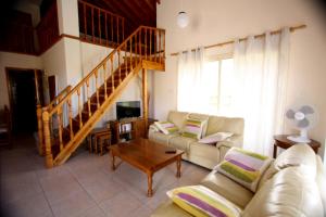 a living room with a couch and a table at Hilltop Chalet in Pissouri
