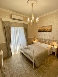 1 dormitorio con cama blanca y lámpara de araña en Domus Valadier B&B Guesthouse, en Fiumicino