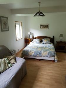1 dormitorio con cama y sofá en Les Gites de la Renardière en Gueures