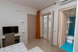 Habitación con cama, escritorio y TV. en Silvia Affittacamere, en Lampedusa