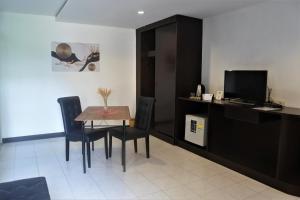 a dining room with a table and chairs and a television at Hi Karon Beach in Karon Beach