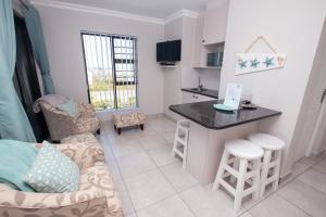 a kitchen and living room with a couch and a table at Van Den Berg's Guesthouse in Bettyʼs Bay