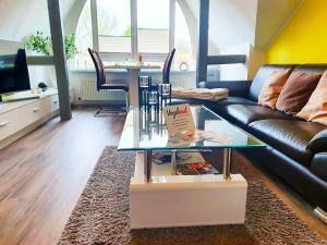 - un salon avec un canapé et une table en verre dans l'établissement Vogelnest, à Mühlhausen