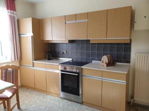 a kitchen with wooden cabinets and a stove top oven at Ferienhaus Renate in Straden