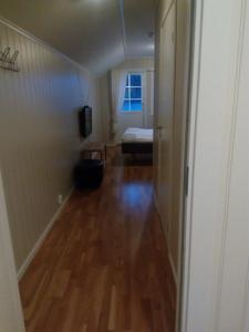 una stanza vuota con un corridoio con pavimento in legno di Dalselv hotell a Stien