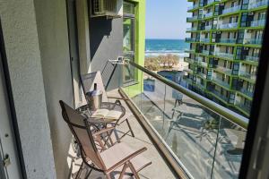 a balcony with a table and chairs and the ocean at Sea Love apt SPA n Pools Beach Resort in Mamaia Nord