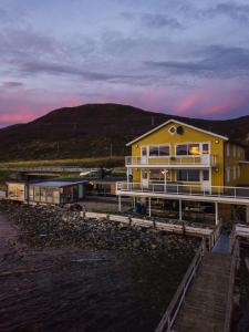 una casa sulla riva di uno specchio d'acqua di Buvik Sea Lodge Apartments a Buvik