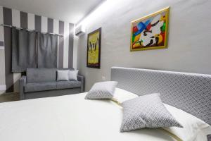 a bedroom with a white bed and a chair at Foresteria Lombarda GELSO BIANCO in Cogliate