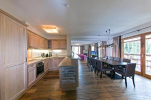 kuchnia i jadalnia ze stołem i krzesłami w obiekcie Serfaus Mountain Lodge w mieście Serfaus