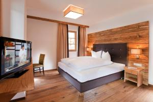 sypialnia z łóżkiem i telewizorem z płaskim ekranem w obiekcie Serfaus Mountain Lodge w mieście Serfaus