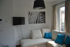 een woonkamer met een witte bank en een zebrafoto bij Casa Conte in Colico