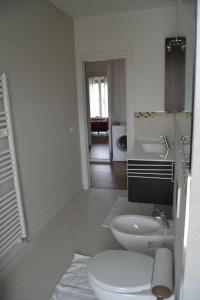een witte badkamer met een toilet en een wastafel bij Casa Conte in Colico