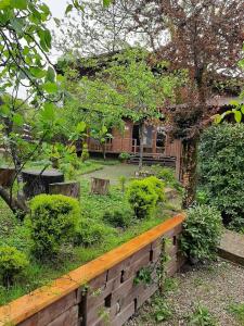 un jardin avec un banc en bois devant une maison dans l'établissement Pican, à Goudaouta