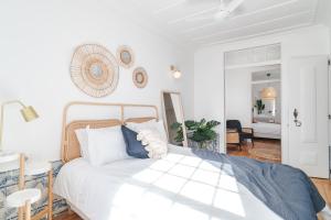 a bedroom with a white bed with blue pillows at Casa Boma Lisboa - Typical and Spacious Apartment - Lapa II in Lisbon