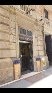 een hotelingang met twee bloempotten voor een gebouw bij Hotel Altavilla in Rome