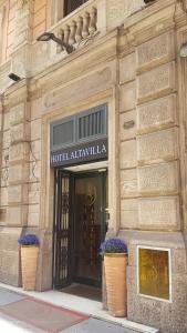 un ingresso dell'hotel con due vasi di fiori di fronte a un edificio di Hotel Altavilla a Roma