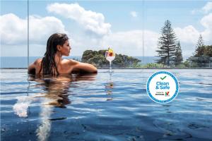 a woman in the water with a martini glass at Aqua - Pópulo Eco Village in Ponta Delgada