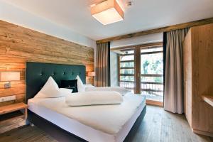 sypialnia z dwoma łóżkami i dużym oknem w obiekcie Serfaus Mountain Lodge w mieście Serfaus