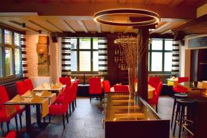 a restaurant with red chairs and tables in a room at Romantik Hotel Schwan in Horgen