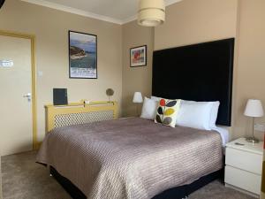 a bedroom with a large bed with a black headboard at Number 29 - Only Adults in Shanklin