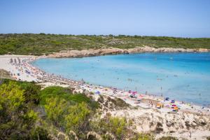 a beach with a bunch of people in the water at Sol Parc Hotel & Apartments in Son Parc