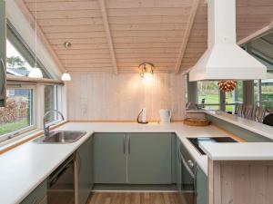 a kitchen with green cabinets and a white counter top at 7 person holiday home in G rlev in Gørlev