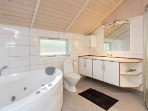 a bathroom with a tub and a toilet and a sink at 7 person holiday home in G rlev in Gørlev