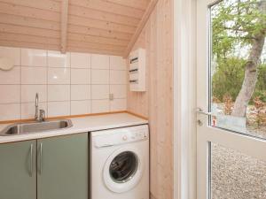 a washing machine in a small kitchen with a window at 7 person holiday home in G rlev in Gørlev