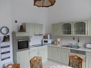eine Küche mit weißen Schränken und weißen Geräten in der Unterkunft Ferienwohnung Fedler in Blankenburg