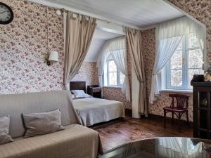 プシュキンスキエ・ゴリにあるСоседи Пушкинаのベッドルーム1室(ベッド1台、ソファ、窓付)