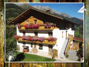 a house with flowers on the balconies of it at Fewo-Egger-Thalmann in Virgen