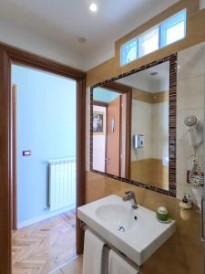 baño con lavabo y espejo grande en Soggiorno Rubino en Florence