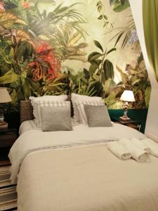 ドーヴィルにあるMagnifique deux pièces au calmeのトロピカルな壁紙のベッドルーム1室(大型ベッド1台付)