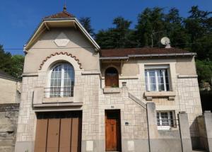 een oud huis met twee ramen en een deur bij Appartement Bel Etre Langeais in Langeais