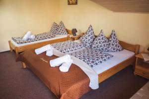 two beds in a hotel room with towels on them at Garni Limbový Dvor in Vrbov