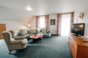 ein Wohnzimmer mit 2 Sofas und einem TV in der Unterkunft Appartementhaus Achmannhof in Bad Füssing